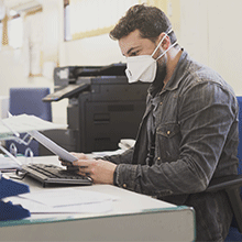 Man wearing face mask working at desk